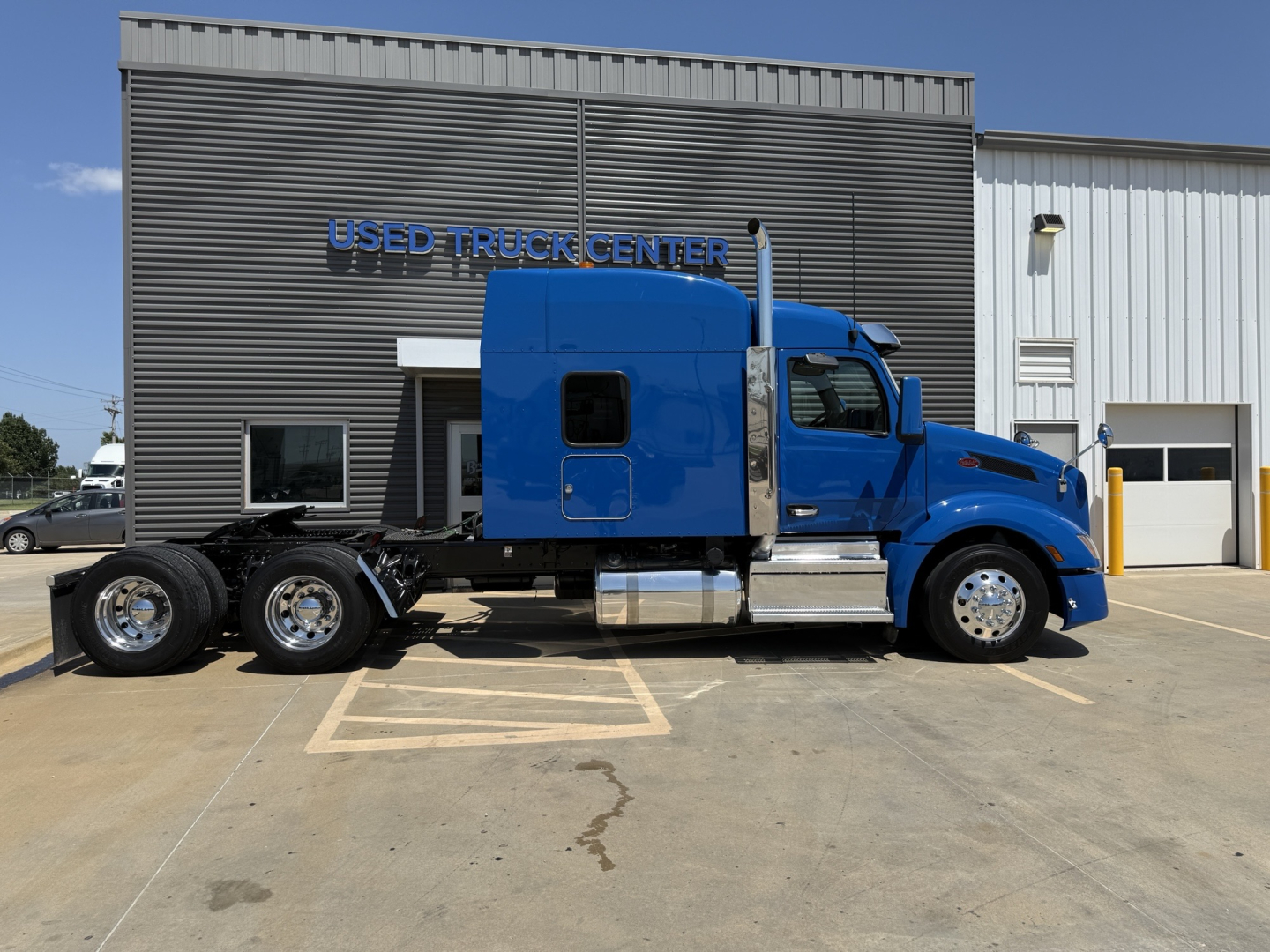 Peterbilt 579 conventional sleeper truck parked in lot showing blue cab and chassis, side view, in-service condition.