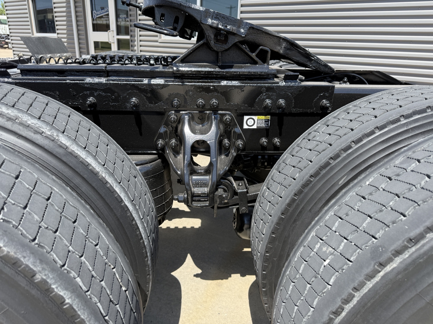 Peterbilt 579 truck chassis showing rear axle suspension and undercarriage, dual rear wheels, frame rails, and mounting hardware.