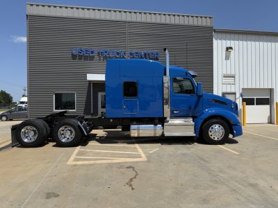 Peterbilt 579 conventional sleeper truck parked in lot showing blue cab and chassis, side view, in-service condition.