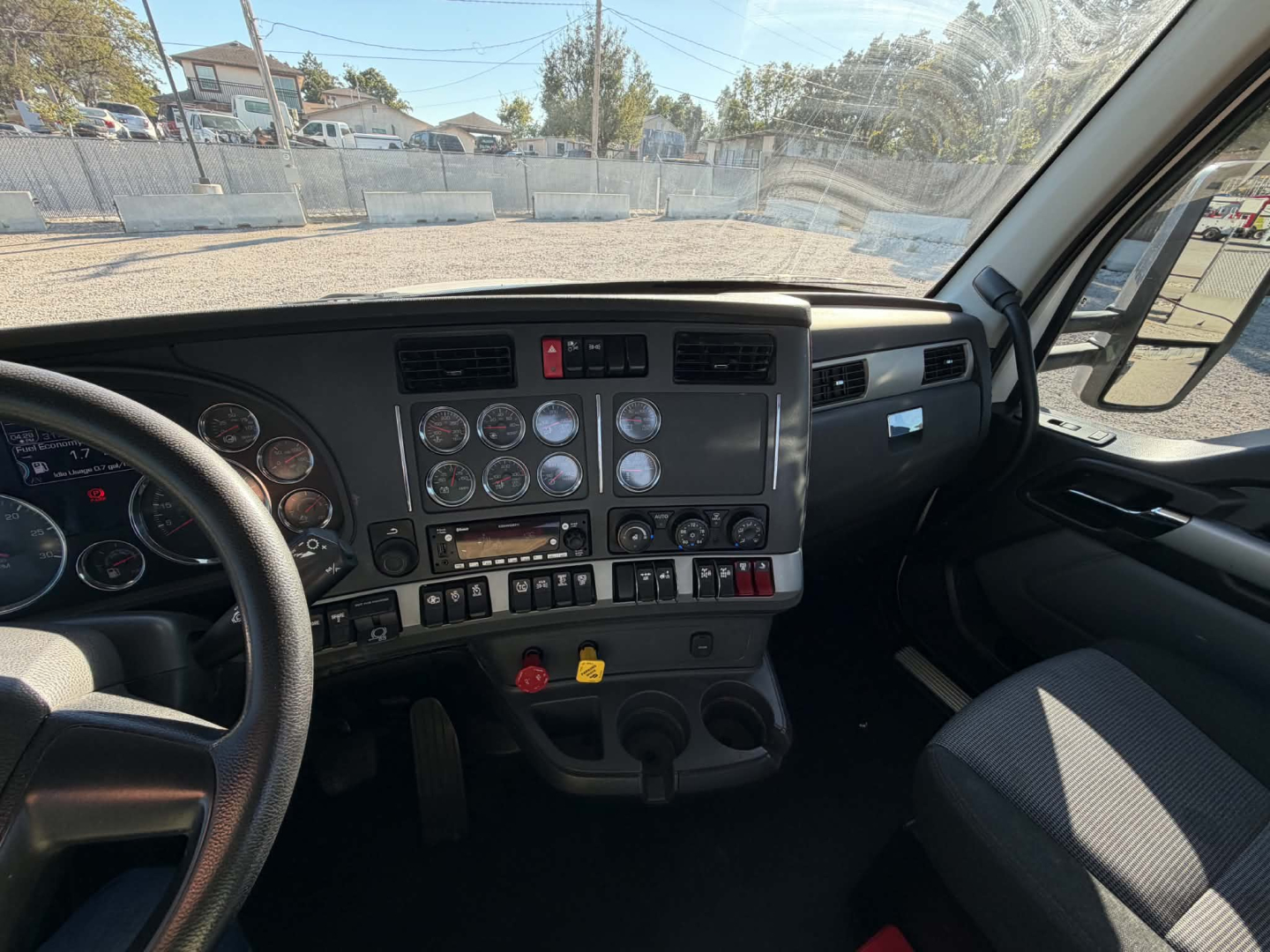 Kenworth T880 cab interior dashboard view with steering wheel and gauge cluster.