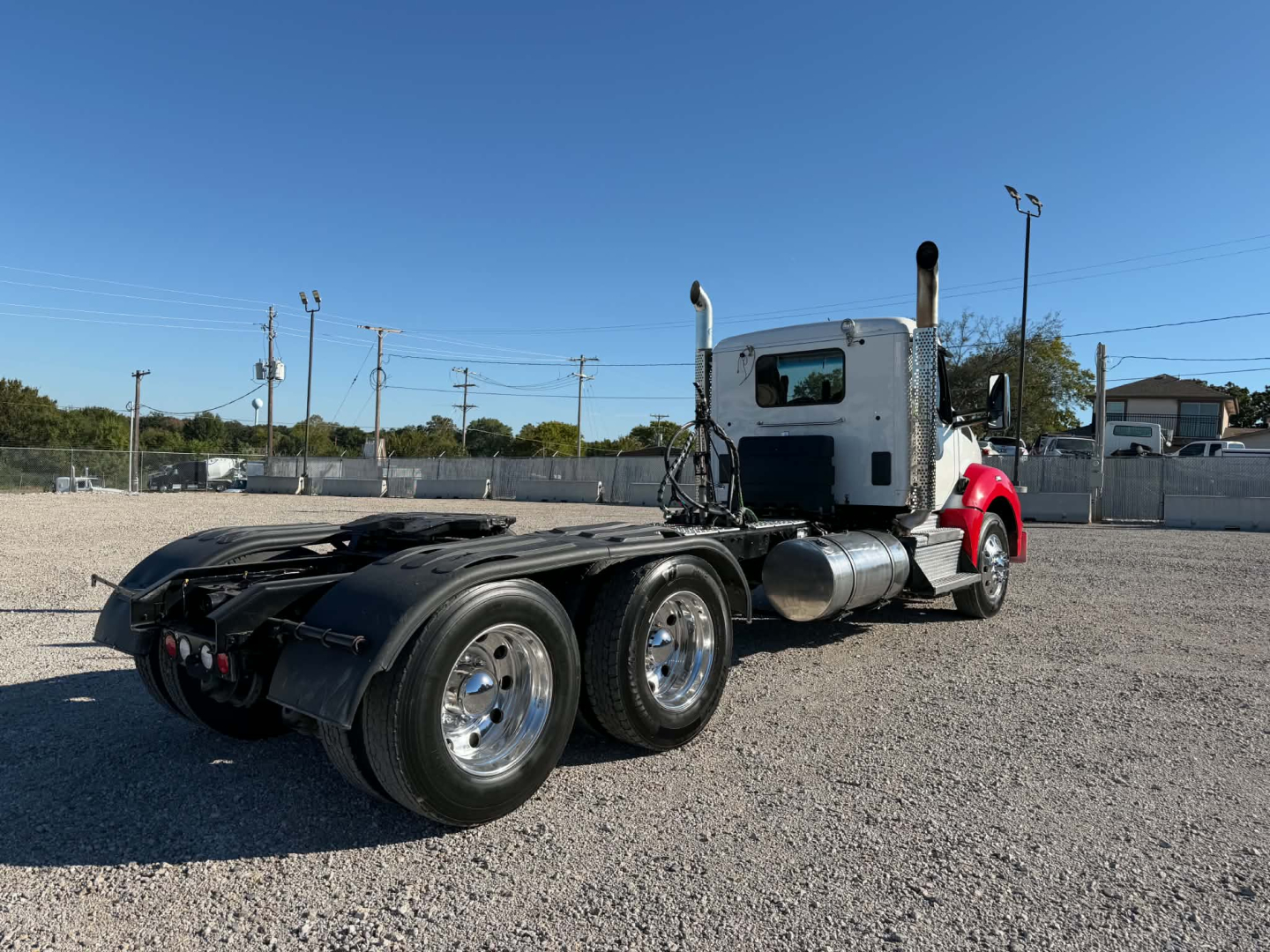 Kenworth T880 truck chassis and cab view showing side with dual rear axles and chrome fuel tanks.