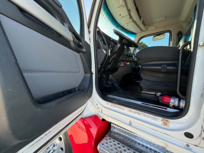 Kenworth T880 cab interior and doorway showing dashboard steering wheel and door sill.