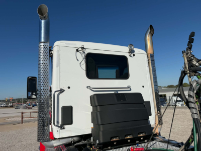 Kenworth T880 cab rear view showing exhaust stacks and rear window.