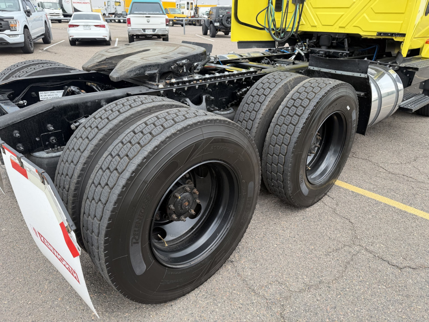 Truck rear dual axle and tires of a 2023 International LT625 conventional daycab showing dual rear wheels and chassis.