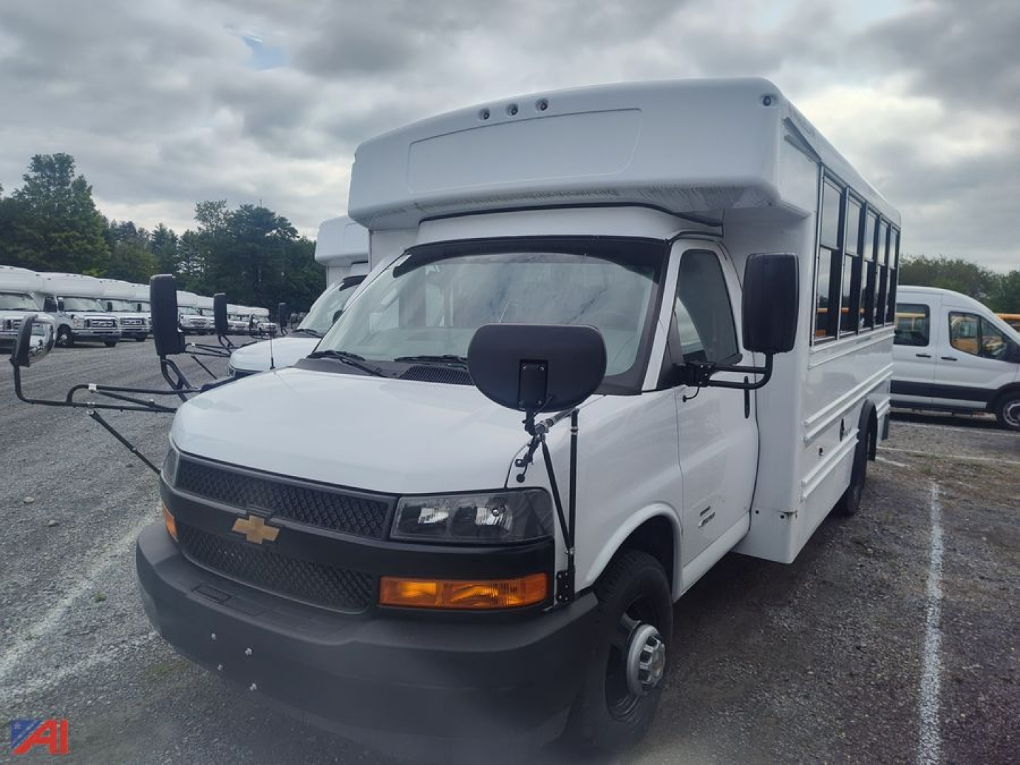 Bus with white body, Chevrolet Express G4500 MFSAB configuration showing front grille, headlights, turn signals, black mirrors, and raised roof; no visible text readable.