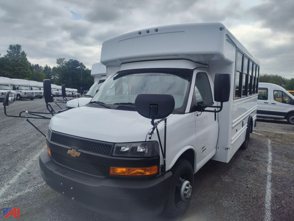 Bus with white body, Chevrolet Express G4500 MFSAB configuration showing front grille, headlights, turn signals, black mirrors, and raised roof; no visible text readable.