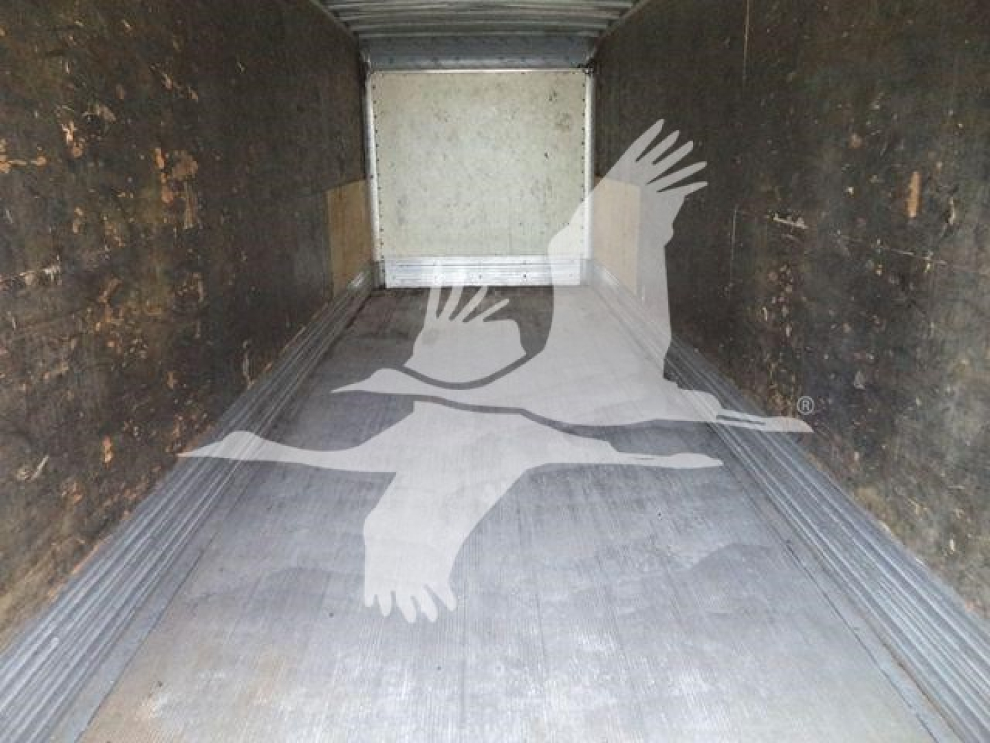 Truck cargo area interior showing wooden side walls and steel floor of a box truck.