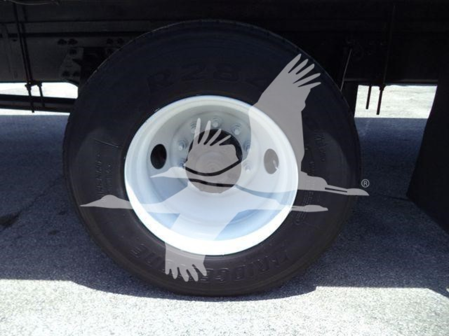 Wheel close-up of a 2020 Hino 268A truck showing a white rim and tire with visible tread, undercarriage shadows.