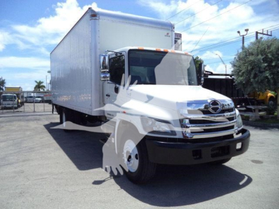 2020 Hino 268A box truck front-left view showing large white cargo box, chrome grille, Hino emblem, and side mirrors.