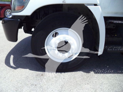 Front wheel and fender of a white 2020 Hino 268A box truck showing front tire and wheel well.