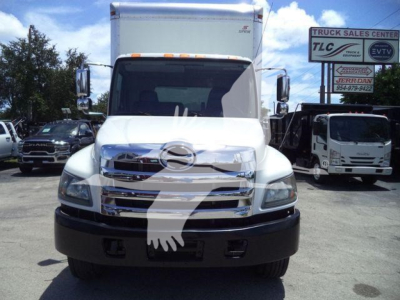 Hino 268A truck front view showing chrome grille, large bumper, and box truck cargo area.