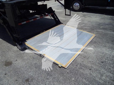 Truck liftgate on a 2020 Hino 268A showing a lowered metal platform with yellow edges and gray surface.