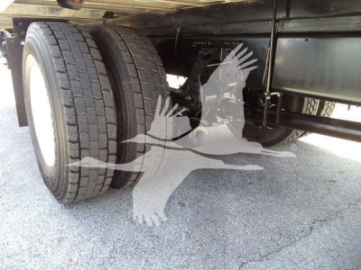 Rear dual-wheel truck axle undercarriage with tires and frame visible; no legible hardware labels readable.