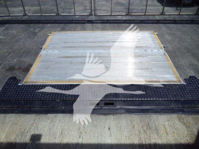 Hino 268A truck bed with aluminum floor and yellow corner protectors, viewed from rear with ramp and diamond plate wheel area.