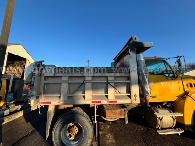 2009 International 7400 dump truck side view showing bed and cab with yellow exterior and metal dump bed.