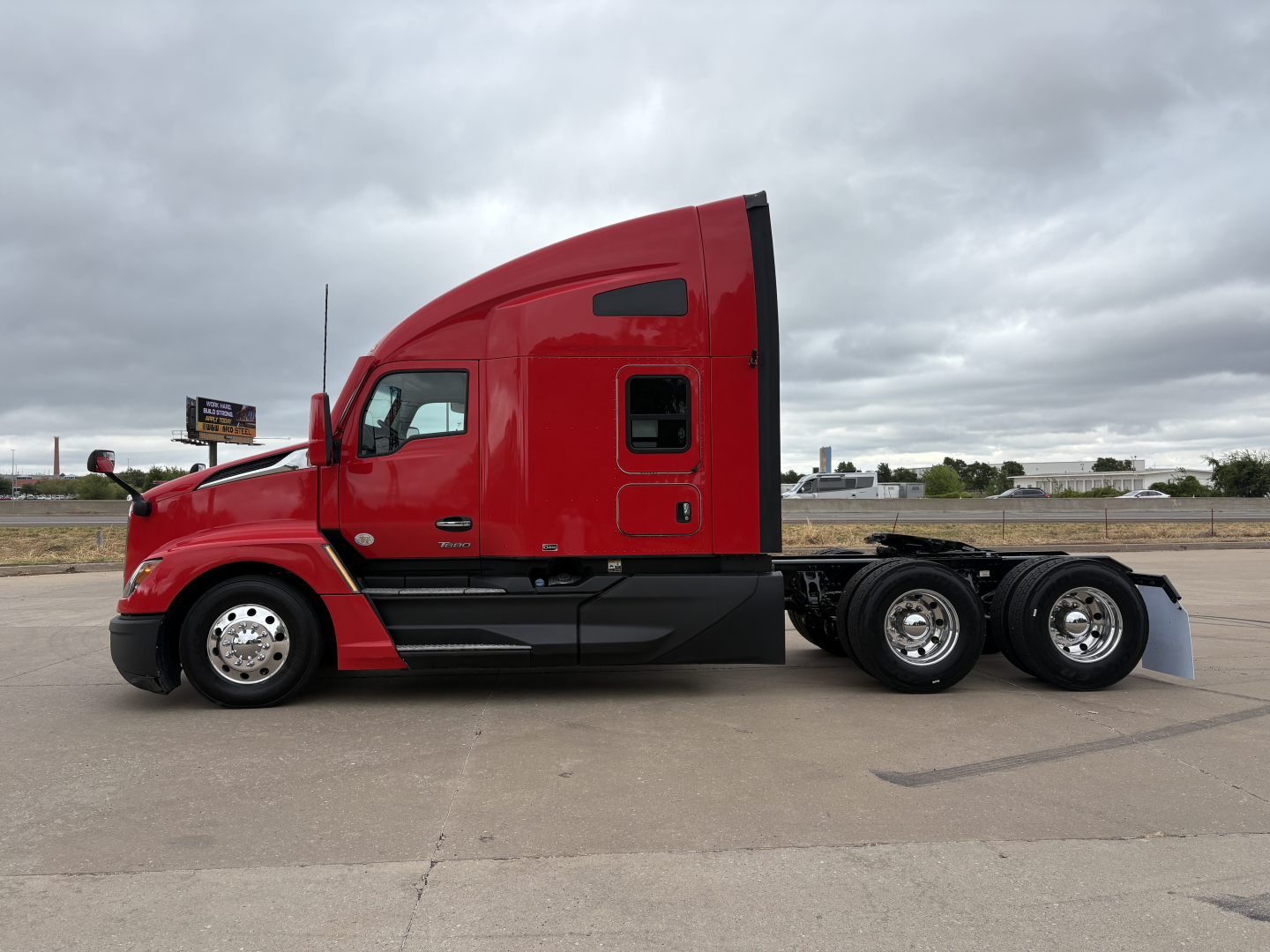 Kenworth T680 truck side view showing red sleeper cab with black chassis and rear dual axles.