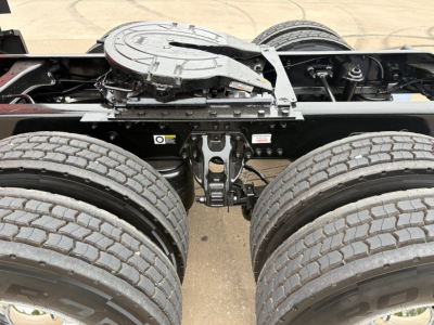 Kenworth T680 chassis view showing dual rear axles and fifth wheel mounting with exposed frame and suspension components.