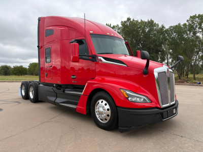 Kenworth T680 tractor red in-service with sleeper cab, front three-quarter view showing chrome grille, aerodynamic mirrors, and dual rear axles.