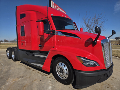 Kenworth T680 conventional sleeper truck in red, front-left view, showing cab, hood, side mirror, and dual rear axles.