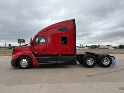 Kenworth T680 side profile showing red cab and black chassis, with sleeper cab and triple rear axles, no visible text or labels.