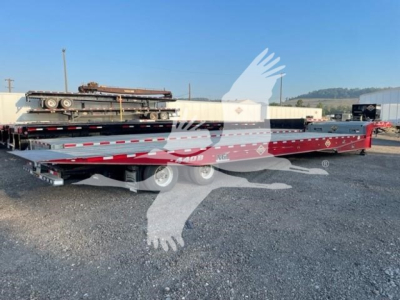 Landoll 440B trailer in view showing long lowbed deck with red color and dual-axle configuration; visible VIN tag in background.