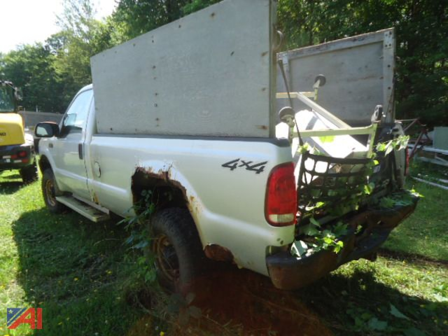 Ford F-250 Super Duty pickup truck with 4x4 badge and rear plow mounting, white exterior, rust on wheel wells, cargo box open tailgate visible.