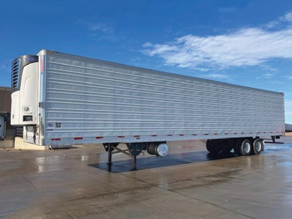 Utility 3000R trailer in side view showing refrigerated unit on front, tandem axle, aluminum side, blue sky.