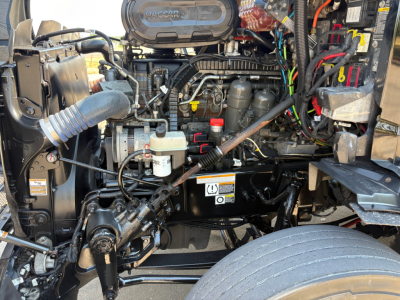 Peterbilt 579 engine bay showing top view with air intake, hoses, and electrical harnesses visible.