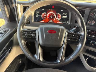 Peterbilt 579 steering wheel and dashboard view from driver seat showing digital gauge cluster and controls.