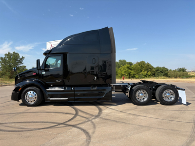 Peterbilt 579 tractor-trailer in dark color side view showing sleeper cab and rear axles
