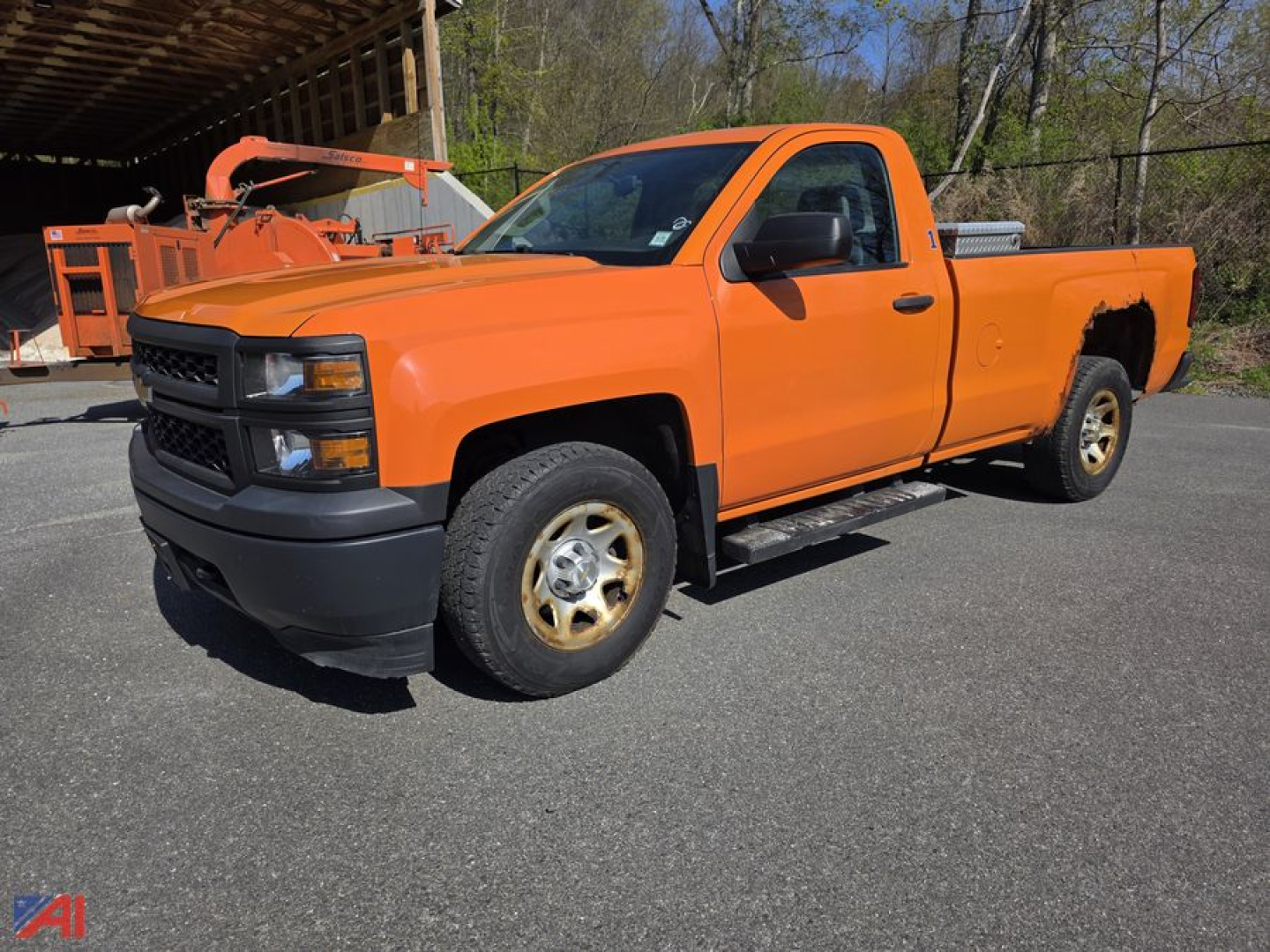 Orange 2015 Chevrolet Silverado 1500 pickup with toolbox in bed, single cab, 4x4, front black bumper and wheels on pavement.