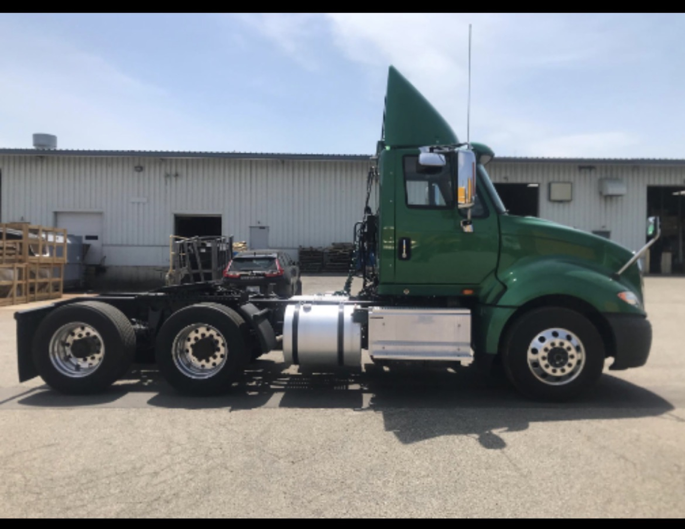 Green 2017 International Prostar+ cab and chassis truck side profile showing dual rear axles, fuel tank, and exhaust stack.