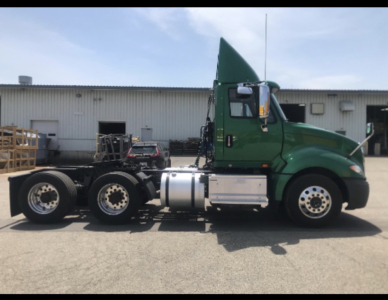 Green 2017 International Prostar+ cab and chassis truck side profile showing dual rear axles, fuel tank, and exhaust stack.