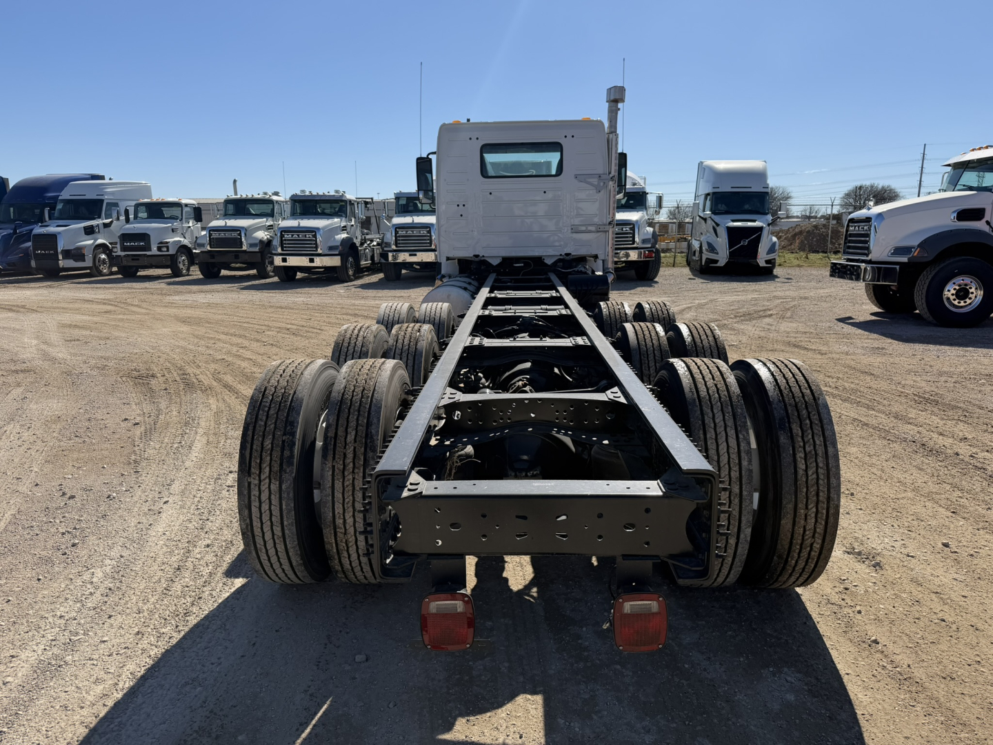 Volvo VHD86B300 cab and chassis rear view showing dual rear axles and mounting frame with red taillight housings.