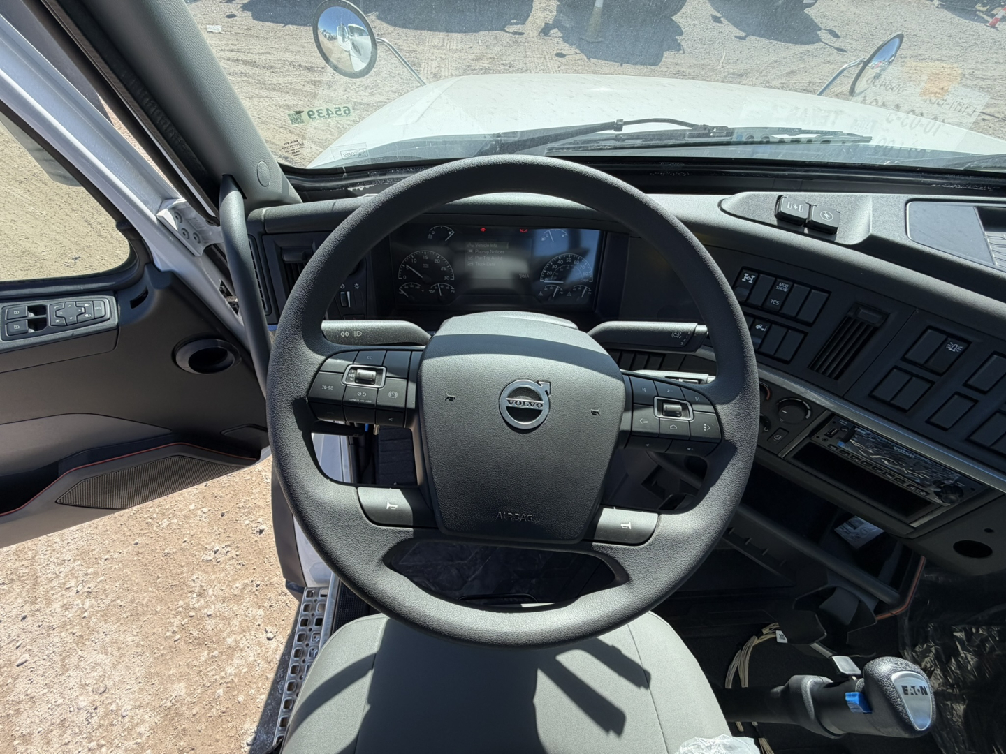 Interior of a Volvo VHD86B300 cab and chassis showing steering wheel with Volvo emblem, dashboard, and driver controls.