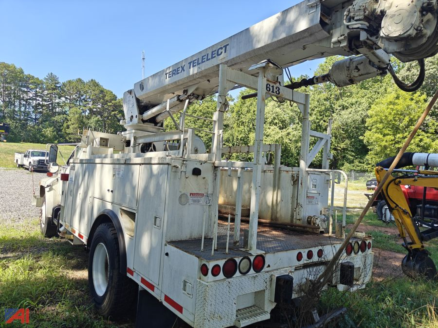 Ford F-700 aerial bucket truck rear view showing Terex Telect boom and service bed with toolbox and lights.