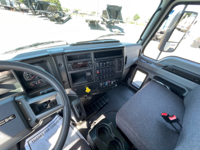 Mack MD6 cab interior showing steering wheel, dashboard with gauges, center console, and driver seat.