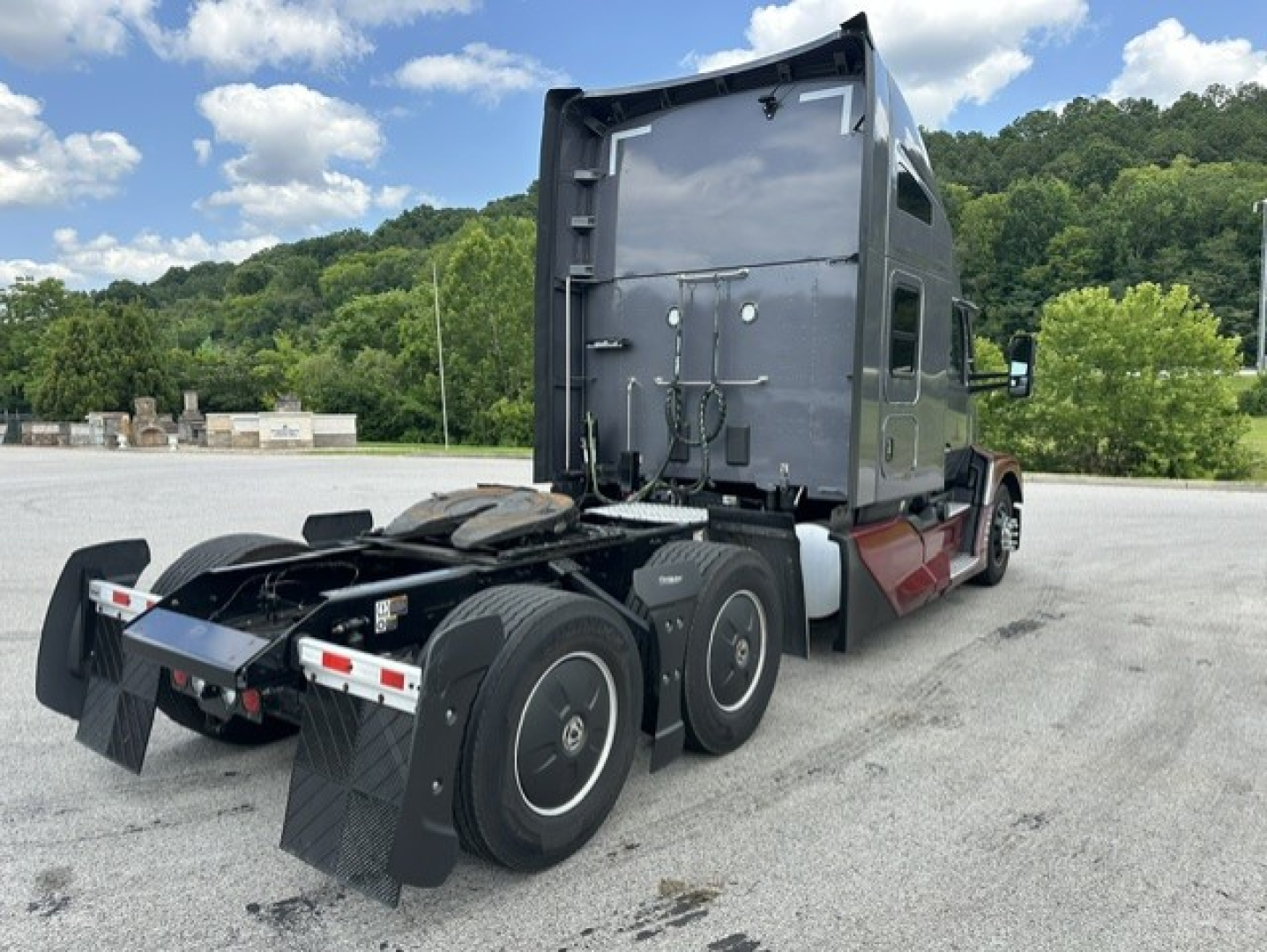 Kenworth T680 tractor rear view showing dual rear axles with mud flaps and sleeper cab, no visible text on components.