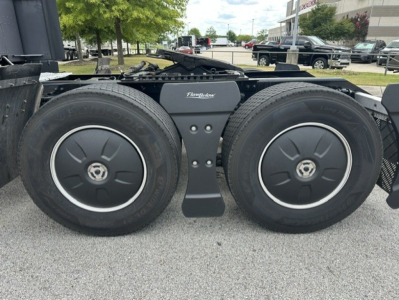 Dual rear wheels of a Kenworth T680 tractor showing Wheel covers and suspension crossmember with FleetBilt branding.