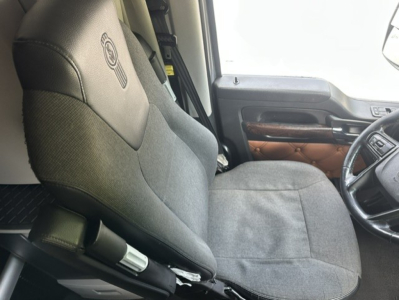 Kenworth T680 truck interior seat and steering wheel view showing fabric seat and door panel