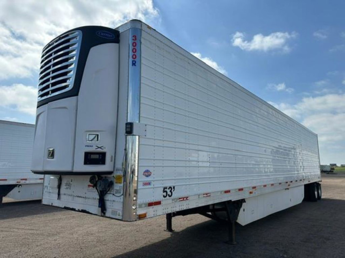 Refrigerated utility trailer with a front refrigeration unit showing a vertical support post and 53' length; exterior white corrugated sides and a blue-green refrigeration unit grille.