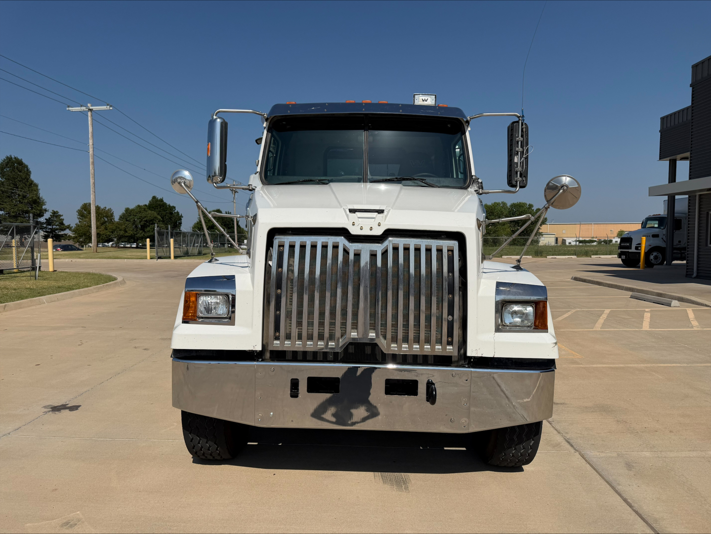 Front view of a white 2017 Western Star 4700SF dump truck with large chrome grille, rectangular headlights, and bumper.