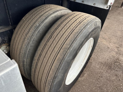 Dual rear wheels of a 2017 Transcraft Combo Flatbed trailer showing worn tread and white rims.