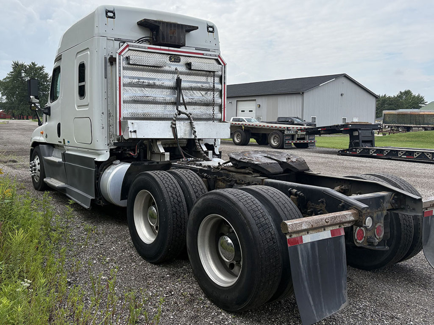 Truck rear view showing fifth-wheel area and dual rear axles of a Freightliner Cascadia125 tractor with a silver sleeper cab, no trailer attached.