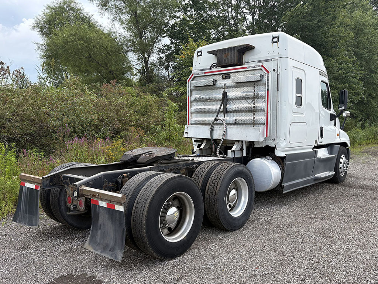 2014 Freightliner Cascadia125 sleeper cab semi-truck chassis rear view showing dual rear axles and fifth wheel mounting.