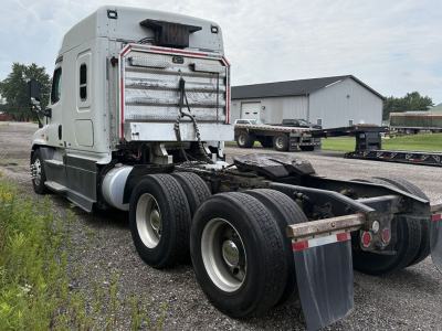Truck rear view showing fifth-wheel area and dual rear axles of a Freightliner Cascadia125 tractor with a silver sleeper cab, no trailer attached.