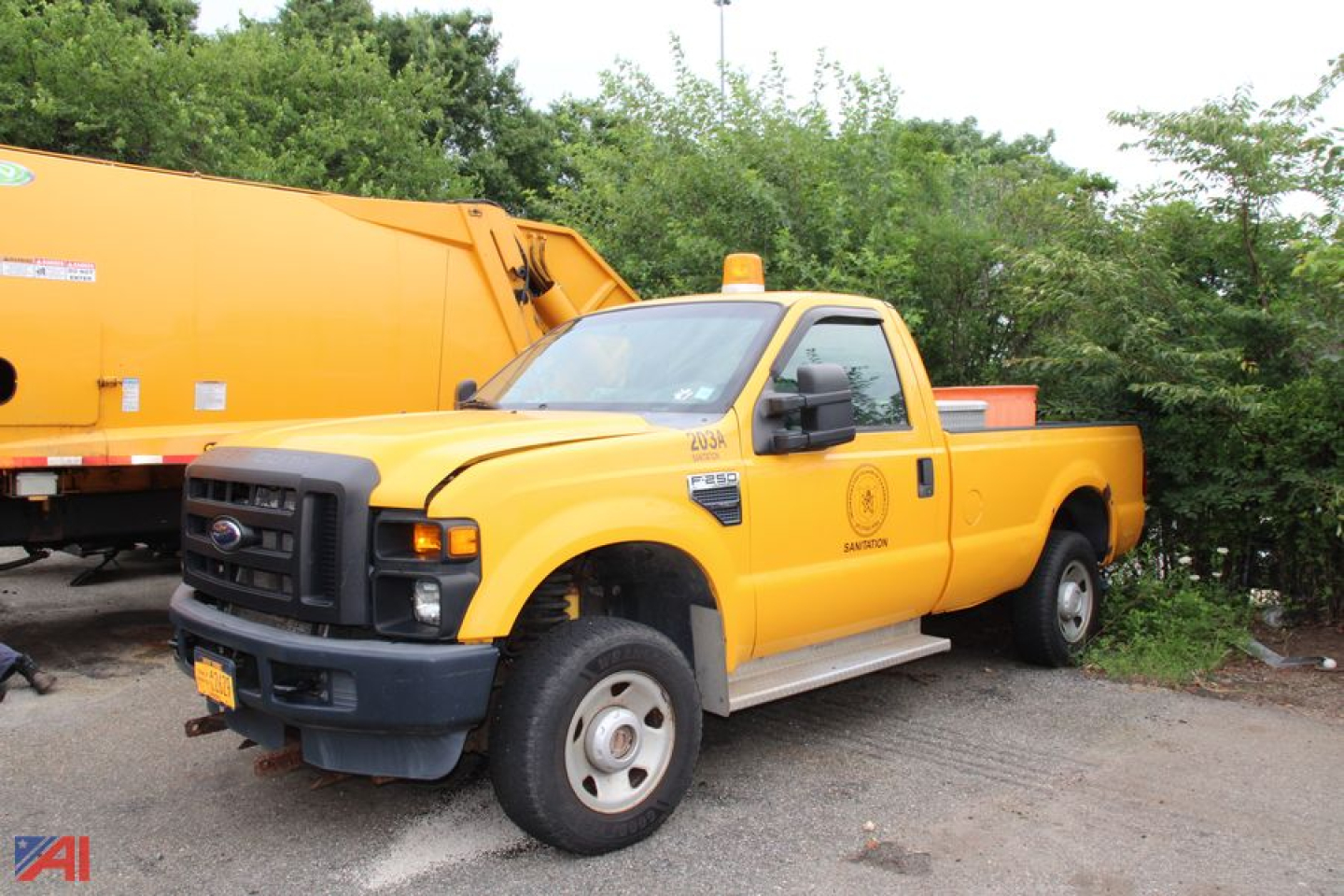 Ford F-250 Super Duty pickup truck in yellow 4x4 parked beside an orange utility vehicle, showing side view with crew cab and utility bed.