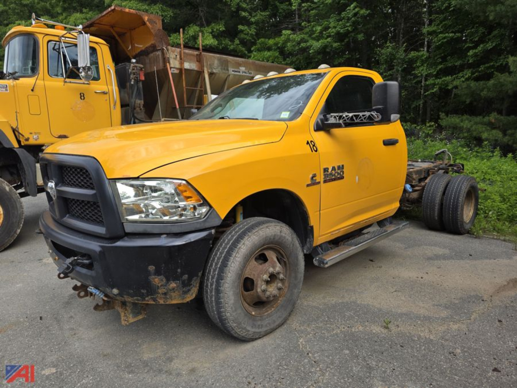 2017 Ram 3500 Cab & Chassis in yellow showing front left view with Ram badge and partial dual rear wheels; dirt on tires and lower bumper; utility truck yard in background
