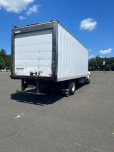 Rear/side view of a 2014 Hino 258/268 reefer truck with white box, double rear doors, and chassis visible.