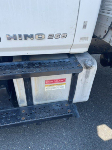 Hino 268 side view showing diesel fuel only label on fuel tank; diesel fuel warning sticker visible under cab with steps.